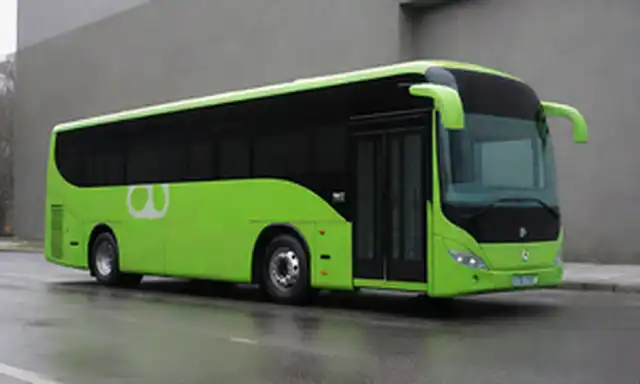 moderno bus con diseño elegante, puerto de carga eléctrico a lado, ruedas futuristas, fuente de energía verde, características interiores innovadoras, paleta de color minimalista, líneas limpias, forma aerodinámica