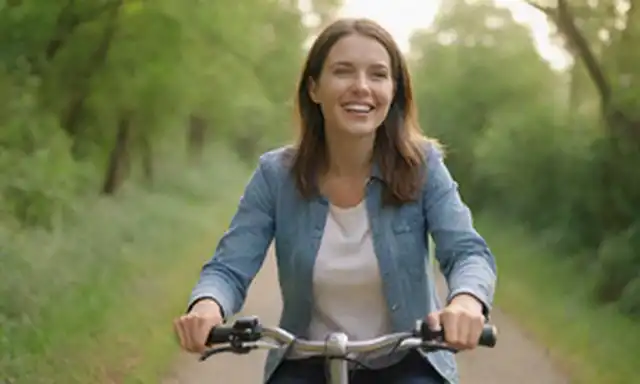 Un entorno sereno, al aire libre con una mujer montando una bicicleta eléctrica, usando ropa casual y sonriendo, frente a un exuberante fondo verde, con una línea de horizonte débil, unos pocos árboles o plantas visibles, iluminación cálida y un efecto borroso sutil