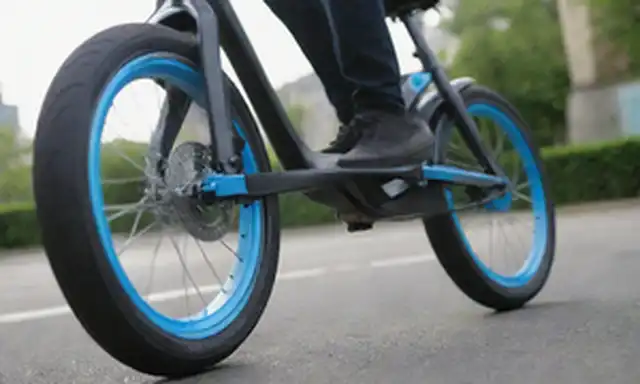 un cierre de una rueda delantera de e-bikes con diseño elegante, acentos azules eléctricos, y aleaciones de plata, un jinete en movimiento borroso en el fondo, pavimento con el sol y un paisaje urbano con edificios modernos y vegetación