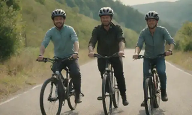2 bicicletas eléctricas con alta autonomía, montando en una carretera de montaña, sol brillando, colinas y árboles en el fondo, jinetes sonriendo, postura relajada, manillar, atmósfera libre y aventurera, atuendo urbano-casual