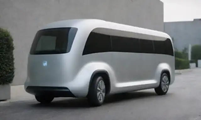 Una toma de cerca de una camioneta eléctrica X-BUS con diseño modular, exterior de plata elegante, luces LED brillantes y líneas futuristas, rodeada de un fondo minimalista limpio, mostrando su forma aerodinámica, ruedas prominentes y curvas dinámicas