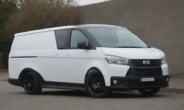 una camioneta compacta blanca, coche eléctrico, faros LED, arcos de rueda audaces, kit de cuerpo ABT, rayas deportivas, mueble negro mate, espejos laterales elegantes, ruedas de aleación de plata, contraste de techo, diseño moderno