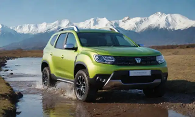 2023 New Dacia Diseño exterior Duster Hybrid 140, capacidad off-road en terreno áspero, vehículo estacionado en paisaje montañoso con picos cubiertos de nieve, esquema de color audaz, faros y detalles de la parrilla, ondeando a través de un río poco profundo, silueta SUV contra el cielo azul, neumáticos robustos, acentos cromáticos