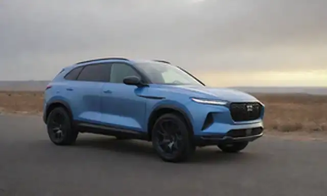 SUV con diseño elegante, potencia eléctrica, faros futuristas, rejilla audaz, cuerpo aerodinámico, ruedas deportivas, líneas de flujo, acabado metálico y una posición dinámica