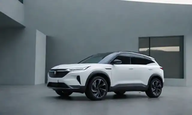 eléctrico compacto SUV con líneas elegantes, elementos futuristas de diseño, faros LED, ruedas aerodinámicas, esquema de colores vibrantes, interior minimalista moderno, cabina espaciosa con materiales premium, techo de vidrio panorámico y características innovadoras