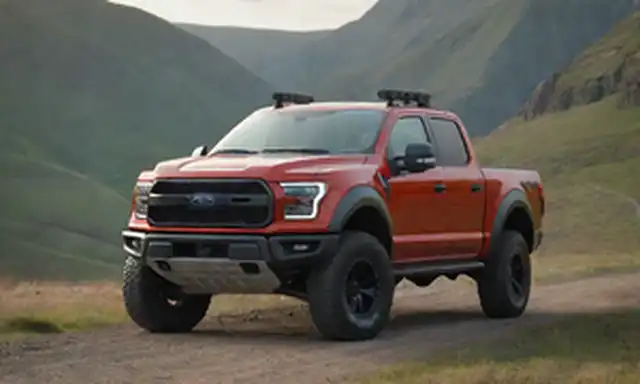 camión de recogida 4x4 con motor híbrido, Ford logo prominentemente exhibido, fuera de la carretera terreno en el fondo, resistentes características de paisaje como rocas y colinas, la luz del sol reflejando fuera de los camiones cuerpo, cable de carga eléctrica coiled en frente o trasero, conductor asiento visible con puerta de pasajero abierto ligeramente, accesorios opcionales como racks de techo o ganchos de remolque