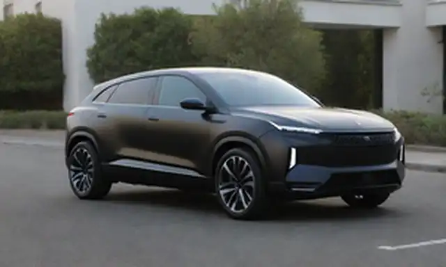 SUV negro elegante, elementos futuristas de diseño, faros LED, faros delgados, líneas aerodinámicas, acabado mate, rejilla prominente, acentos cromados, ruedas de alta tecnología, placa de estilo europeo