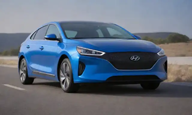 2025 Hyundai IONIQ 2 coche eléctrico con diseño elegante, faros LED futuristas, líneas curvas, color azul vibrante y puerto de carga en el fender trasero