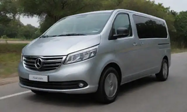 van de 5 puertas, color de cuerpo de plata, bordes redondeados, diseño futurista, puerto de carga en la parte trasera, faros elegantes, amplio parabrisas, amplio interior, asientos lujosos, panel digital, montura de smartphone, tamaño compacto, vibe ecológico
