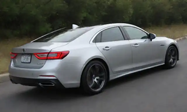 Sedán de 4 puertas, diseño elegante, faros futuristas, luces traseras LED, ruedas aerodinámicas, pintura corporal de plata, spoiler trasero, insignia híbrida, puerto de carga delantero