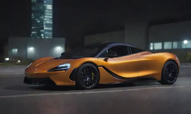 2023 McLaren Auto eléctrico, diseño elegante y futurista, arcos deportivos de rueda, líneas aerodinámicas, rejilla frontal audaz, faros LED, sillones iluminados, posación dinámica en una calle de la ciudad, fondo con paisaje urbano borroso