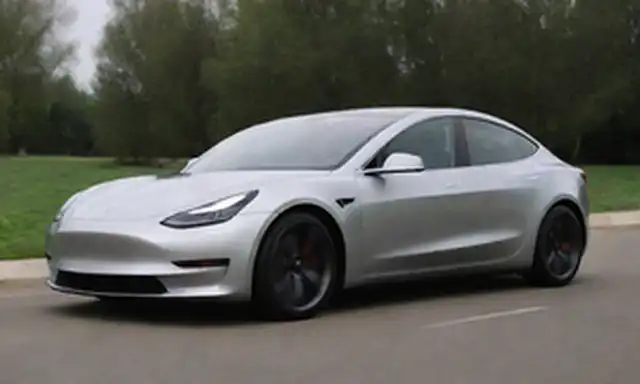 2022 Tesla Model 3 Rendimiento, cuerpo de plata elegante, rejilla frontal agresiva, faros LED delgados, líneas aerodinámicas dinámicas, cucharas laterales prominentes, ruedas de aleación chunky, spoiler deportivo, difusor trasero, y un toque de un diseño futurista
