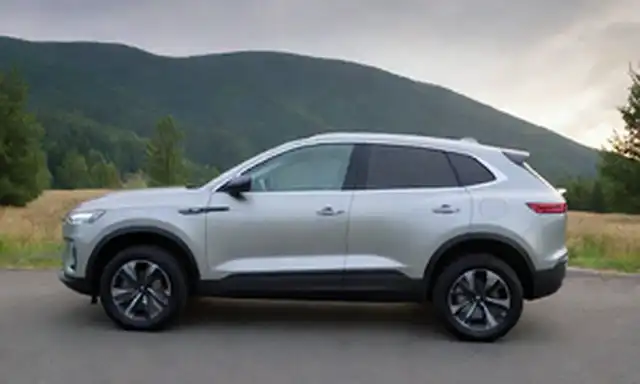 SUV eléctrico de 4 puertas, diseño elegante, líneas atrevidas, ruedas grandes, faros LED, techo panorámico, puerto de carga en el fender frontal, material premium, paleta de color natural, estética escandinava, ambiente exterior con colinas y árboles en fondo