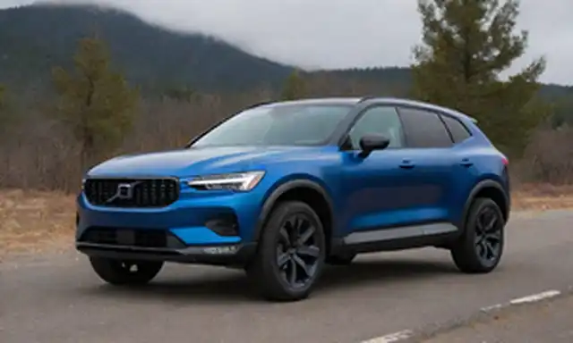 2023 Polestar 4 diseño exterior, color metálico azul oscuro, líneas elegantes, posición dinámica, faros LED, luces de niebla, rejilla frontal agresiva, espejos laterales con señales de giro integradas, carriles de techo negro, grandes ruedas de aleación, contraste de acentos blancos en trim, arcos de rueda de inspiración off-road, terreno resistente