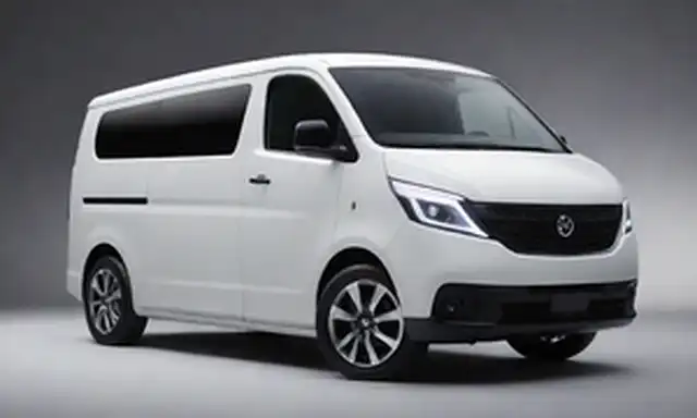 Vista frontal 3/4 de una camioneta eléctrica blanca con un diseño moderno, acentos cromáticos en la parrilla, y faros elegantes; creas y líneas sutiles le dan un aspecto futurista; luces LED brillantes en el techo para mayor visibilidad; ruedas de plata con neumáticos de bajo perfil; parachoques trasero minimalista con reflectores integrados; silueta limpia y simplificada
