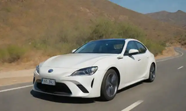 Sedán de 5 puertas, diseño icónico, vista frontal, luz solar de la mañana, campiña española, camino de viento, color blanco, Toyota logotipo prominente, líneas elegantes, faros redondeados, conductor sonriente, ventana abierta, y un toque de vegetación